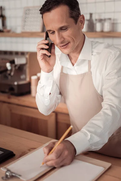 Freudiger netter Mann schaut in sein Tagebuch — Stockfoto