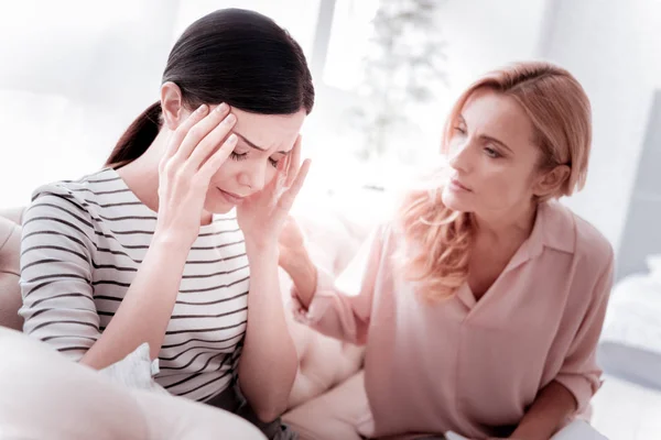 Treurige vrouw sluiten haar ogen en haar psycholoog kijken naar haar — Stockfoto