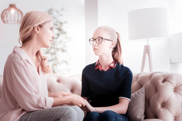 Mère attentive regardant sa fille adolescente tout en étant assise avec elle — Photo