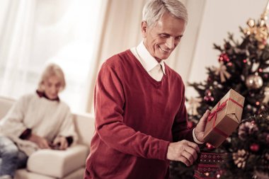Gülümseyen ve bir hediye tutarak baktılar hoş adam.