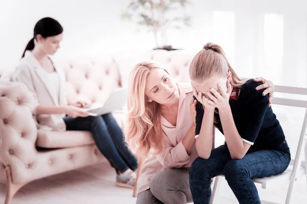 Tonårig flicka gråter och mamman vänlig uppmärksam kramar henne — Stockfoto