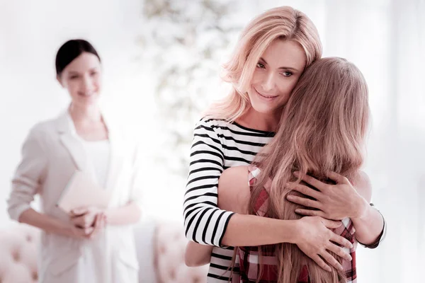 Kalm psycholoog glimlachen tijdens het kijken naar de reünie van een gezin — Stockfoto