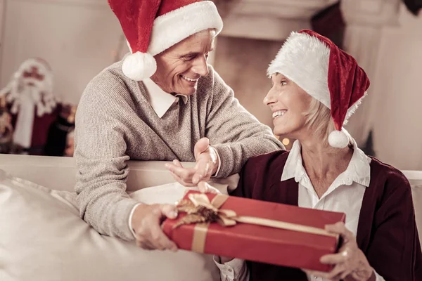 Ευτυχισμένη έκπληκτος γυναίκα ψάχνει άντρα και κρατώντας ένα δώρο. — Φωτογραφία Αρχείου