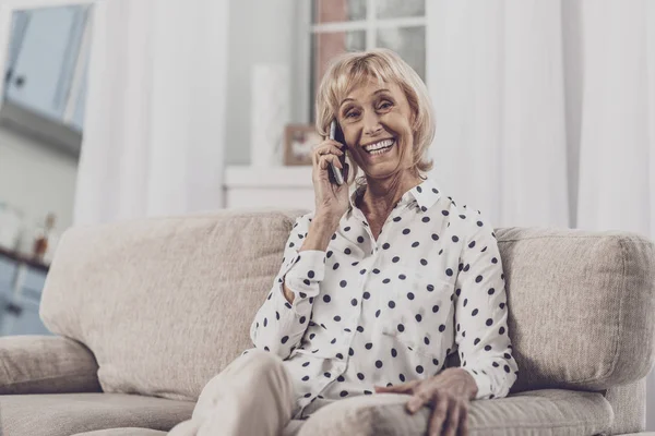 Zářil starší žena nosí strakaté košile mluvit na telefonu — Stock fotografie