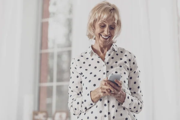 Сияющая леди улыбается во время чтения прекрасного сообщения — стоковое фото