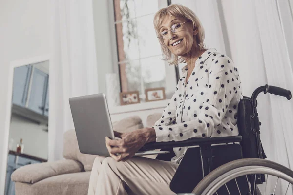 Mujer mayor viendo una película sentada en silla de ruedas — Foto de Stock