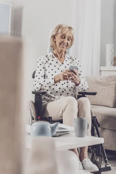 Mujer vistiendo pantalones beige enviando mensajes de texto a su colega — Foto de Stock