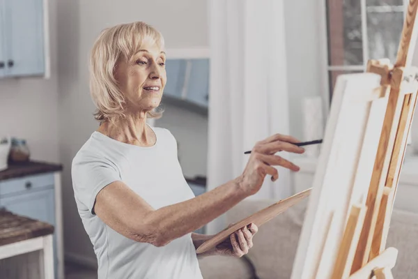 Artist wearing white shirt standing near drawing easel — Stock Photo, Image