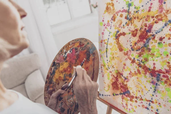 Blond kvinne med fargepalett mens hun tegner – stockfoto