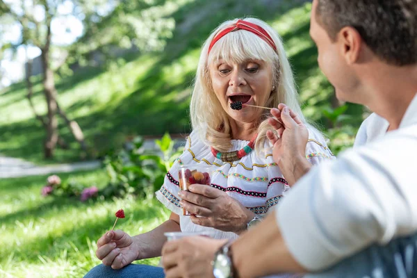 Эмоциональная пенсионерка собирается есть ягоды — стоковое фото