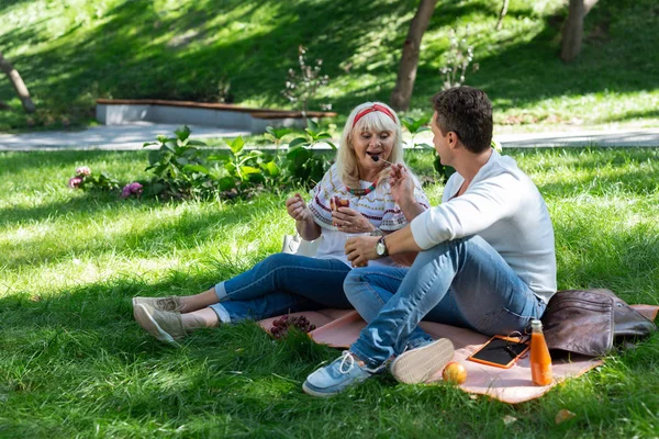 Glada människor ha picknick i grön park — Stockfoto