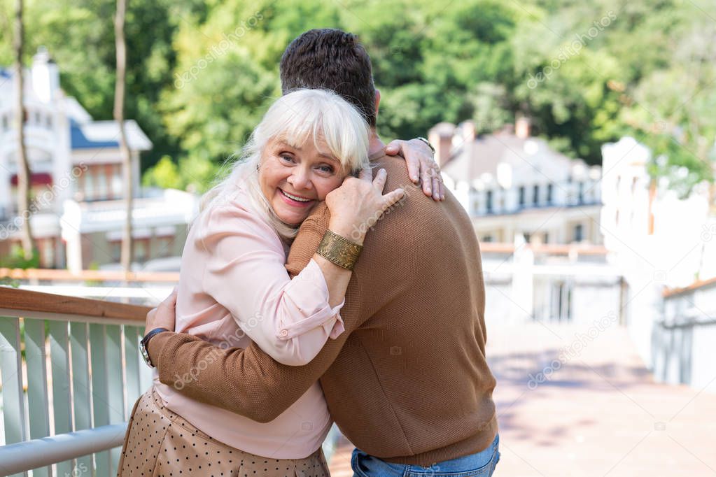 Happy senior female standing near her relative