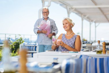 Memnun yaşlı kadın kocası için bekliyor