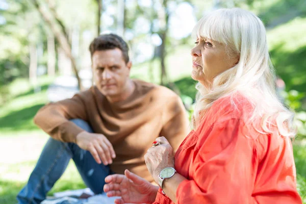 Thoughtful mature woman sitting on the foreground — Stock Photo, Image