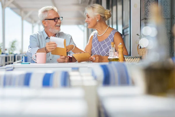 Glückliche alte Frau zeigt auf die Speisekarte — Stockfoto