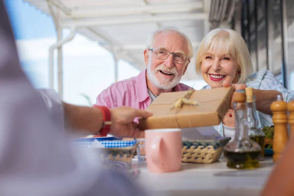 Freudiges positives Paar schenkt seinen Freunden ein Geschenk — Stockfoto