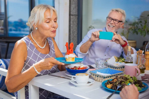 Mujer agradable positivo soplando en las velas — Foto de Stock