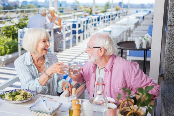 Feliz pareja de ancianos sosteniendo vasos de agua — Foto de Stock