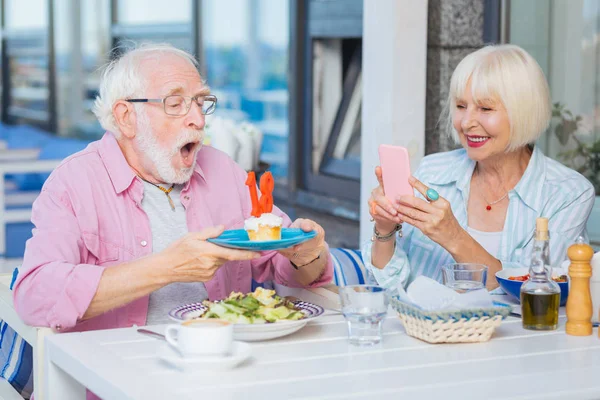 Örömteli boldog idős ember fúj gyertyák — Stock Fotó
