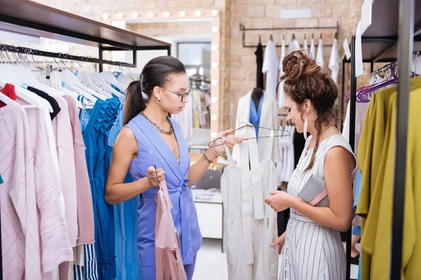 Geconcentreerd vrouwelijke stylist stelt outfit aan vrouw — Stockfoto