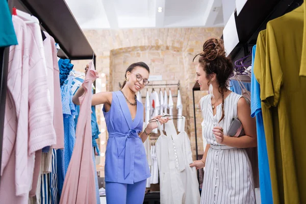 Feliz estilista femenina ofreciendo atuendo a la mujer — Foto de Stock