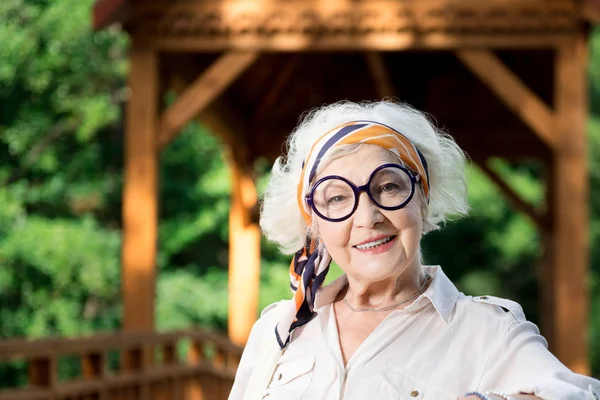 Lakonický portrét starší ženy ve velkých sklenicích šťastně se usmívala — Stock fotografie