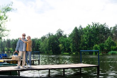 İskelede sarılma ve rahat görünümlü iki üst düzey kişi