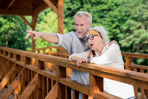 Jubilados emocionados de pie en el puente y mirando a la distancia — Foto de Stock