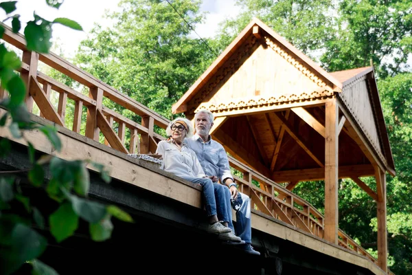 Spokojny emeryci siedzący na drewniany most i Natura — Zdjęcie stockowe