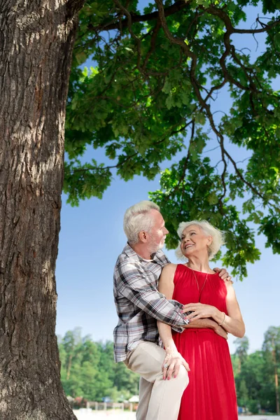 Hermosa pareja anciana sonriendo y sintiéndose feliz mientras se abraza — Foto de Stock