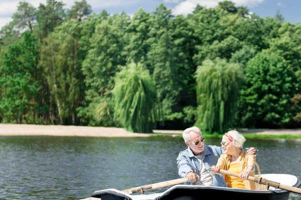 Casal sênior abraçando enquanto aprecia a natureza e passeios de barco — Fotografia de Stock