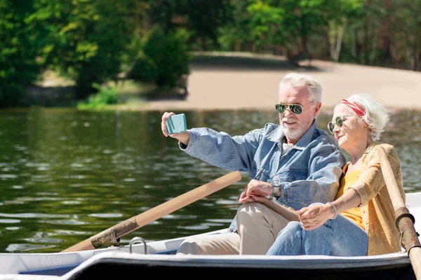 Progressive pensioners taking selfies while rowing and relaxing