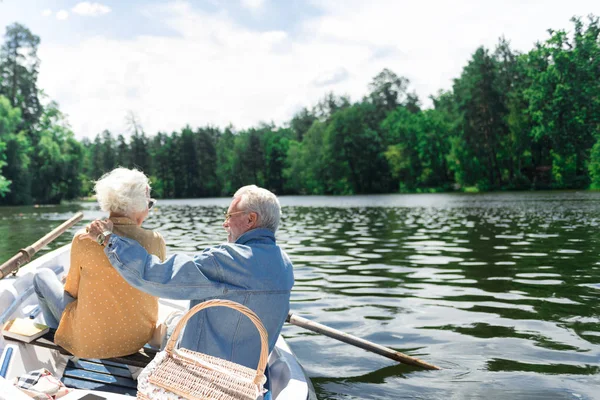 Lovely couple of pensioners hugging in the boat and relaxing