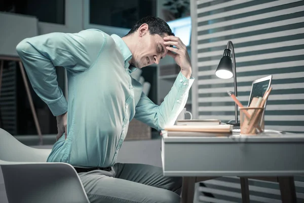 Cansado homem colocando a mão em suas costas — Fotografia de Stock