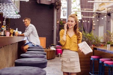 Popüler bar ziyaret ederken telefonda konuşurken rahat genç kız