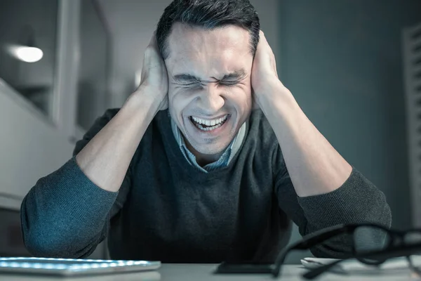 Sconvolto giovane uomo spremitura testa con le mani — Foto Stock