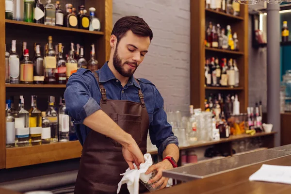 Cuidadoso barman limpiando las gafas mientras está en el trabajo —  Fotos de Stock