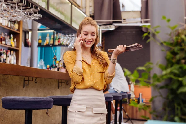 Mujer joven positiva riendo mientras habla por teléfono — Foto de Stock