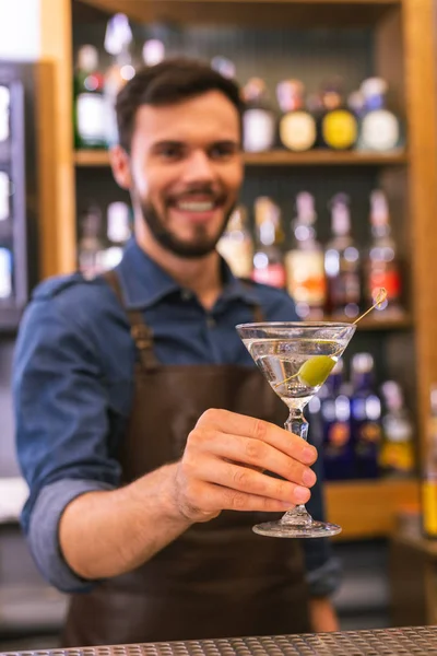 Позитивний бармен посміхається, пропонуючи холодний алкогольний напій — стокове фото