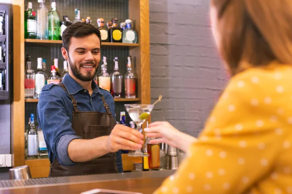 Feliz barman sonriendo al visitante mientras le da alcohol —  Fotos de Stock