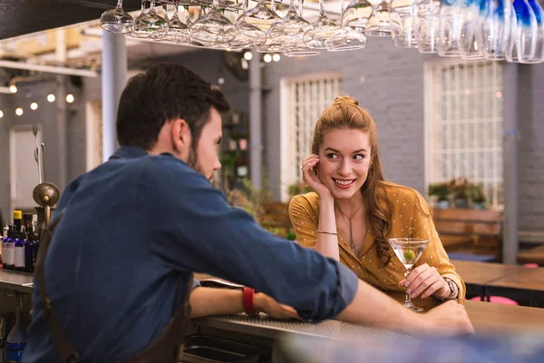 Schattig meisje leunend op de bar teller en flirten met de barman — Stockfoto