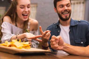 Duygusal arkadaş barda oyun oynarken gülüyor