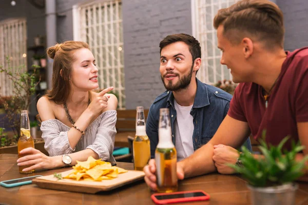 Expressive man making funny faces and his friends looking at him — Stock Photo, Image