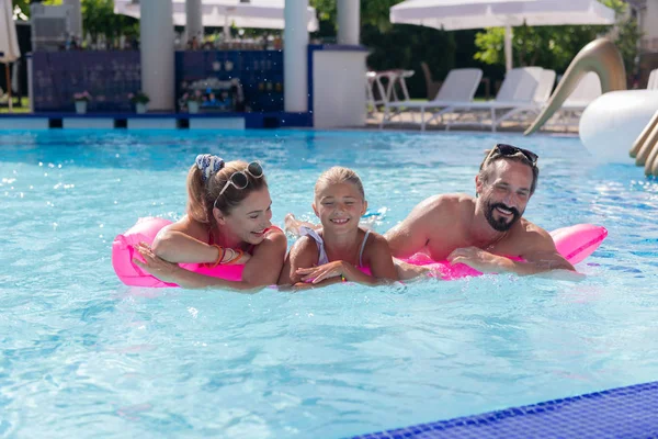 Joyeuse famille positive s'amuser dans la piscine — Photo