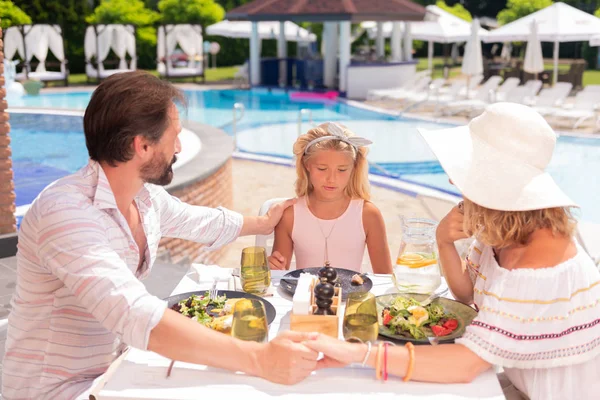 Szép kellemes család étkezés a medence közelében — Stock Fotó