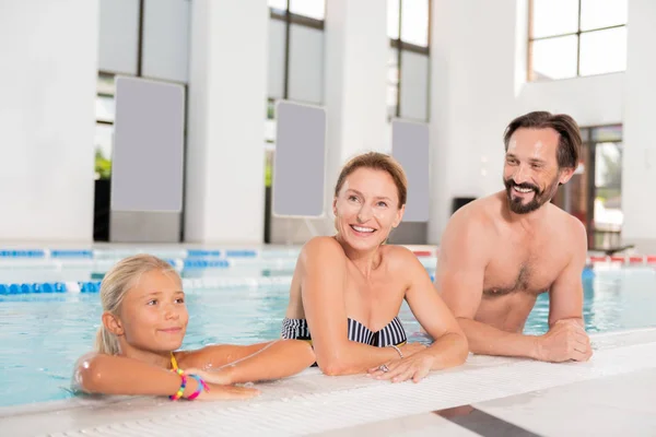Alegre familia agradable visitando una piscina cubierta — Foto de Stock