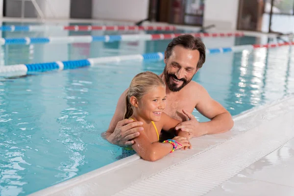 Vrolijke aardige man, een bezoek aan het zwembad met zijn dochter — Stockfoto