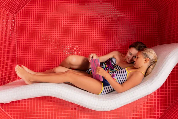 Mulher alegre agradável estar no spa com sua filha — Fotografia de Stock