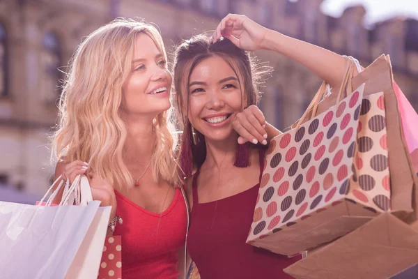 Agradáveis mulheres alegres sentindo-se felizes depois de fazer compras — Fotografia de Stock