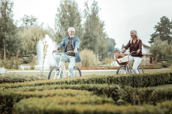 Fröhliche blonde Frau folgt ihrem reifen Partner — Stockfoto